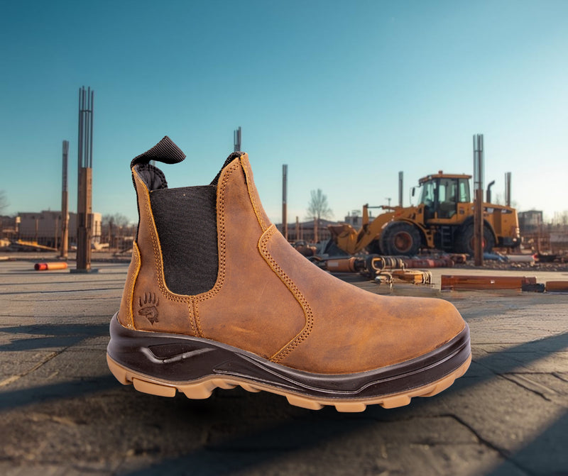 Brown leather pull-on work boot on a concrete slab at a construction site